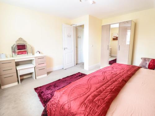 a bedroom with a large bed with a red blanket at Maesbury Manor in Oswestry