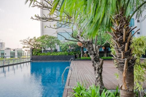 a palm tree next to a swimming pool at DoubleTree by Hilton Jakarta Kemayoran in Jakarta