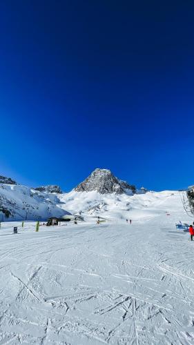 a snow covered slope with a mountain in the background at Appartement esprit chalet - splendide vue montagne à 180 in Val dʼIsère