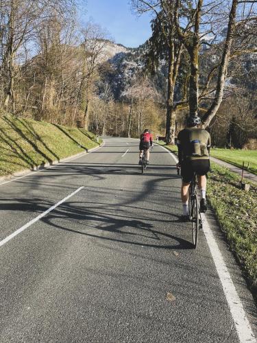 two people riding bikes down a road at Hotel Vötterl in Grossgmain