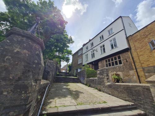 un callejón en una ciudad con un edificio blanco en The Old Church House top floor in private house central Frome, en Frome