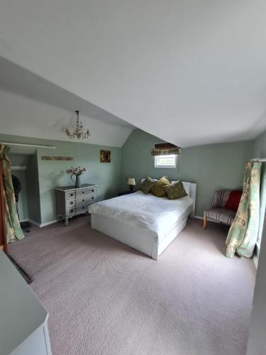 a bedroom with a large white bed and a couch at The Old Church House top floor in private house central Frome in Frome