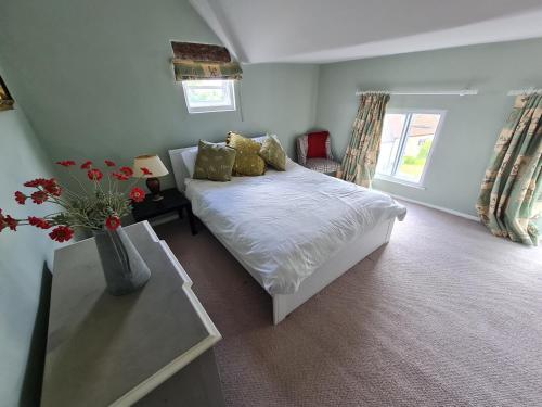 um quarto com uma cama e uma mesa com flores em The Old Church House top floor in private house central Frome em Frome