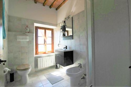 a bathroom with a toilet and a sink at Lo Scricciolo in Montecastelli Pisano