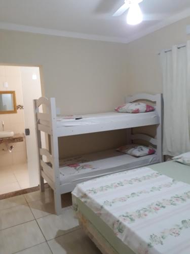 a bedroom with two beds and a desk and a bed at Pousada Frei Galvão in Cachoeira Paulista