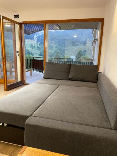 セルレルにあるApartamento Cerler 1540の大きな窓のある客室で、大きなソファが備わります。
