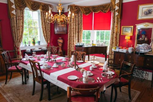a dining room with a table with red walls at Grosvenor Villa in Bath