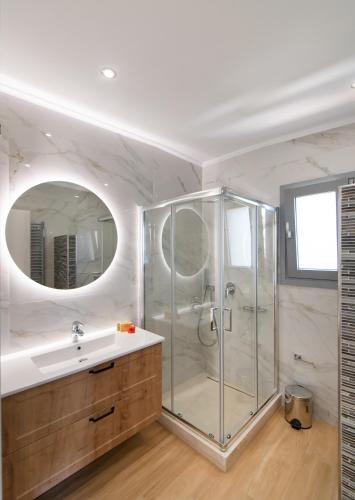 a bathroom with a shower and a sink and a mirror at Aspasia's mansion in Lygia
