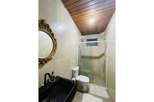 a bathroom with a shower and a sink and a mirror at Morada nas Montanhas Chale 08 in Urubici