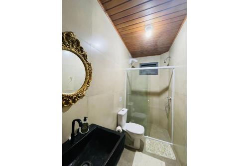 Un baño con ducha, lavabo y espejo. en Morada nas Montanhas Chale 08, en Urubici