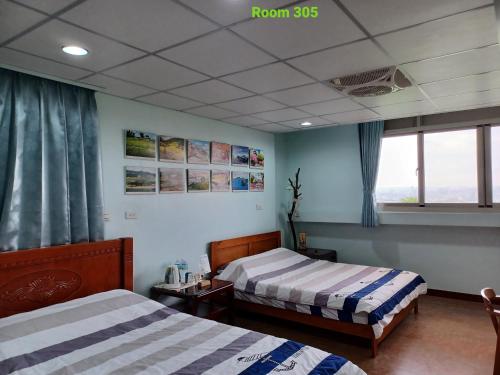 a hotel room with two beds and a window at Smile house Homestay in Taiping