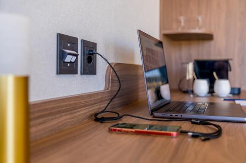 a laptop computer sitting on top of a wooden desk at Hotel D Bulle - La Gruyère in Bulle