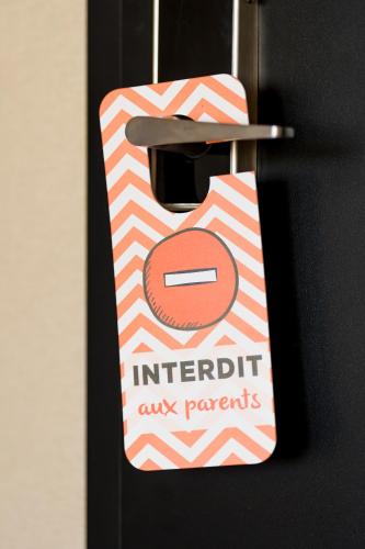a sign hanging on a door with a magnetic door tag at Hotel D Bulle - La Gruyère in Bulle