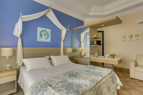 a bedroom with a bed and a desk and a chair at Villas Jurerê Hotel Boutique in Florianópolis