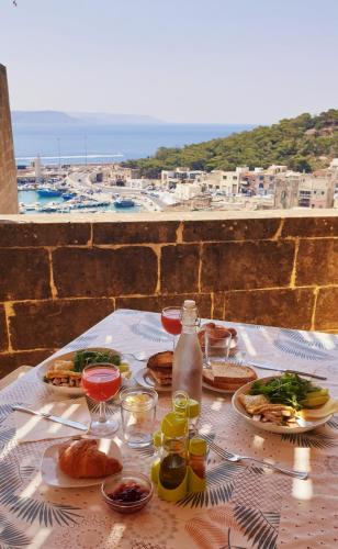 een tafel met eten en drinken en uitzicht op de oceaan bij B&b Seaview terrace in Għajnsielem