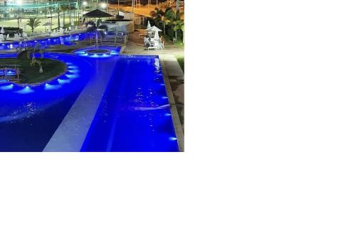a pool with blue lights in a resort at Flat ótima estrutura in Porto De Galinhas