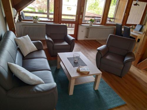 a living room with a couch and two chairs and a coffee table at Ferienwohnungen Gabi Hermann in Bodman-Ludwigshafen