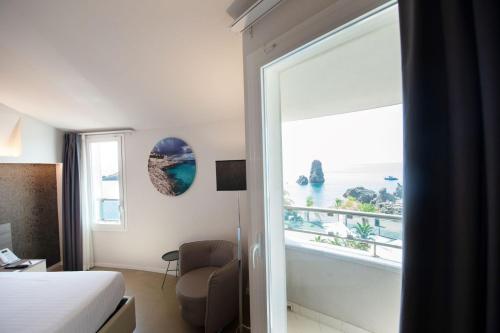 a hotel room with a view of the ocean at Grand Hotel Faraglioni in Acitrezza