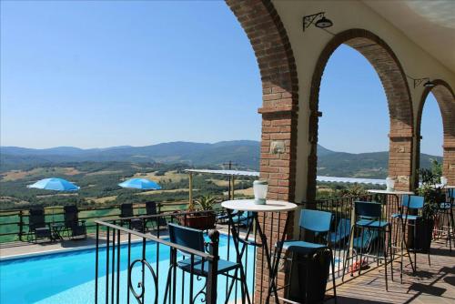 a balcony with a table and chairs next to a pool at Lo Scricciolo in Montecastelli Pisano