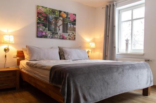 1 dormitorio con 1 cama con una pintura en la pared en Hof Timmermann - Landhaus, unten, en Ottenstein