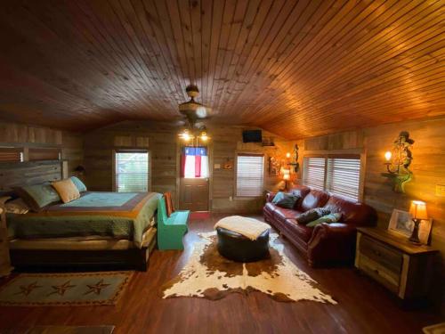 ein Schlafzimmer mit einem Bett und einem Sofa in einem Zimmer in der Unterkunft 8th St. Cowboy Haus I Biker Friendly I River in Bandera