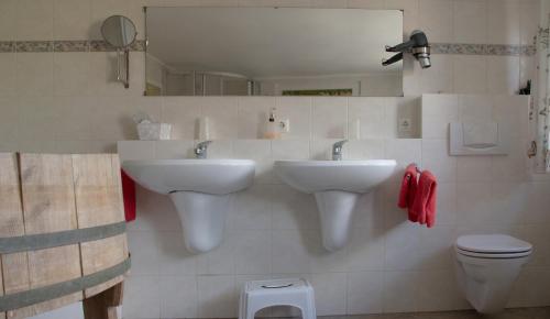a bathroom with two sinks and a toilet at Hof Timmermann - Landhaus, oben in Ottenstein