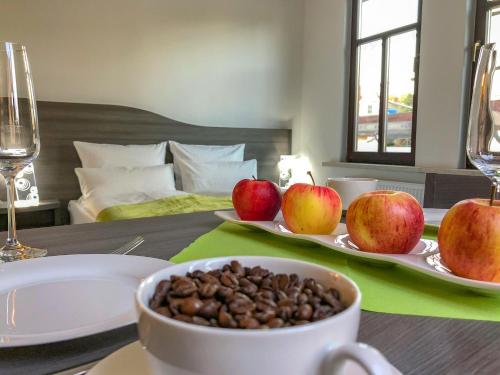 una mesa con un plato de manzanas y un tazón de nueces en Rhöner Ferienwohnung, en Stadtlengsfeld