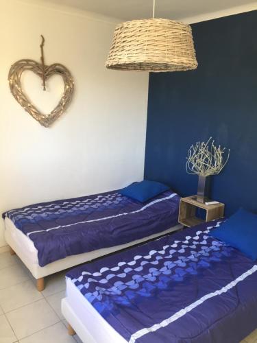 - une chambre avec 2 lits et un panneau cardiaque sur le mur dans l'établissement SETE - 6 Quai Louis Pasteur, à Sète