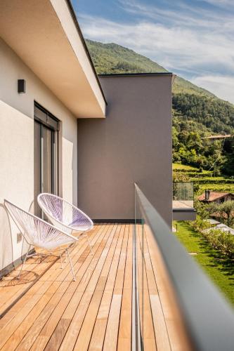 a balcony with two chairs on a wooden deck at Gazzi Apartments 'Panoramic & Relaxing' in Arco