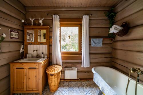 a bathroom with a tub and a sink and a window at Vendégház a hegyen in Budapest