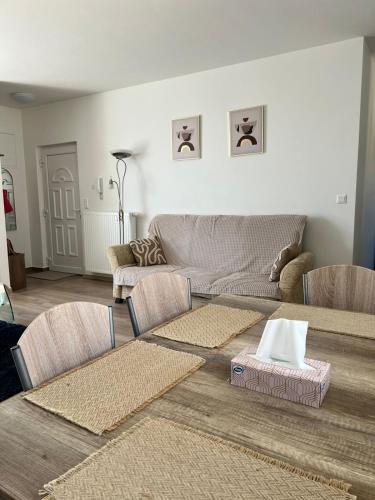 sala de estar con sofá, mesas y sillas en Edmond Apartment, en Hévíz