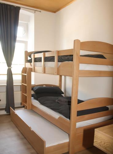 a bedroom with two bunk beds with a window at Gästehaus am Viehmarkt in Hillesheim