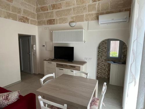 a kitchen and dining room with a table and a television at Donna Maria Pina in Monopoli