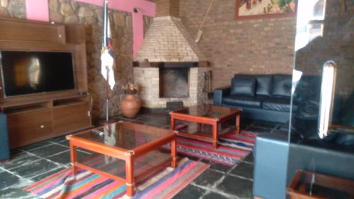 uma sala de estar com um sofá e uma lareira em hosteria camino del inca em Humahuaca