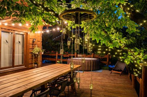 a wooden table and chairs on a deck with lights at Vendégház a hegyen in Budapest