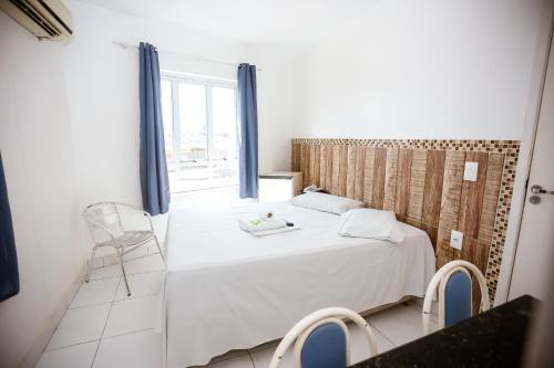 a bedroom with a white bed and a window at Hotel Barão Palace in Teresina
