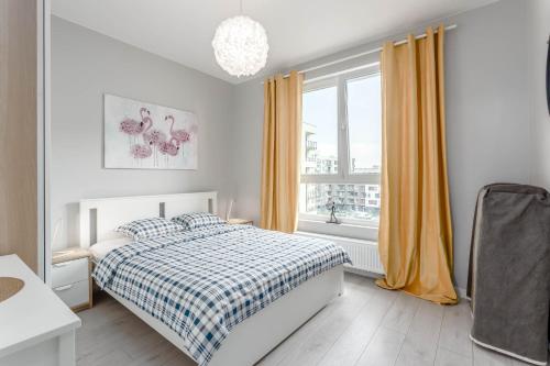 biała sypialnia z łóżkiem i oknem w obiekcie Chill Apartments Ursus w Warszawie