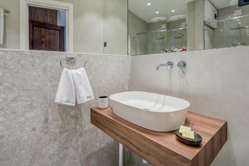 a bathroom with a white sink and a mirror at Makarun Heritage Rooms in Split