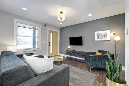 a living room with a couch and a tv at Abode Nashville - Germantown in Nashville