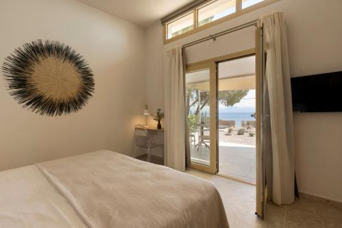 een slaapkamer met een bed en een glazen schuifdeur bij Villa Aura Loutraki in Loutraki