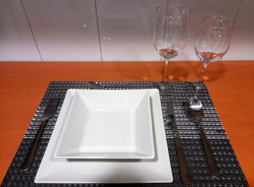 a white plate on a table with two wine glasses at Parque El Retiro Madrid in Madrid