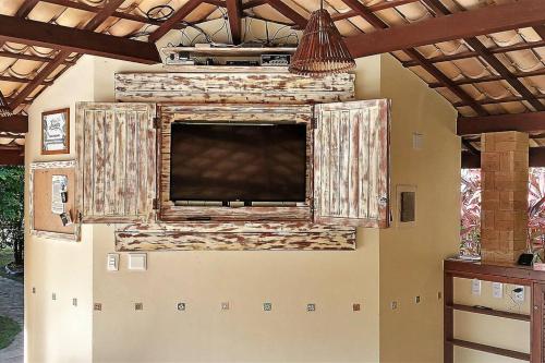 TV grande en la pared de una habitación en Imbassai - Casa Alto Padrão completa - Condominio Fechado - A1B1 en Imbassai