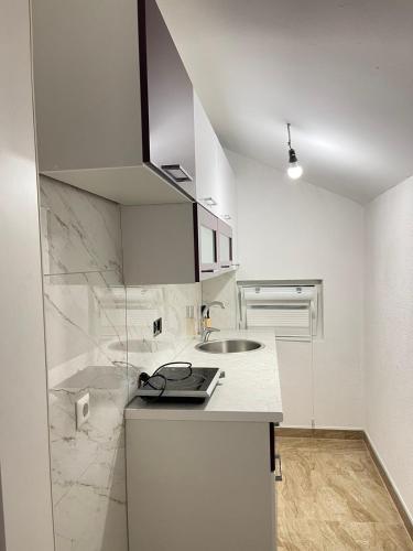 a white kitchen with a sink and a counter at Una Bihac 4 in Bihać