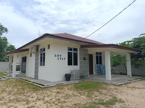 ein kleines weißes Haus mit einem Tisch und Stühlen in der Unterkunft Fadli HOMESTAY in Kota Bharu