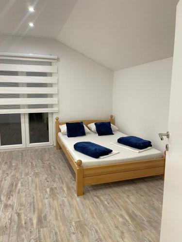 a bedroom with a bed with blue pillows and a window at Una Bihac 4 in Bihać