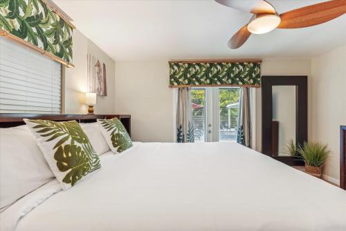 a bedroom with a white bed and a ceiling fan at Sapphire Shores - Sarasota Bungalow w/ Heated Pool and Backyard Oasis in Sarasota