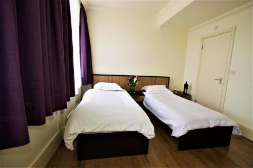 dos camas sentadas una al lado de la otra en una habitación en Pembury Hotel at Finsbury Park, en Londres