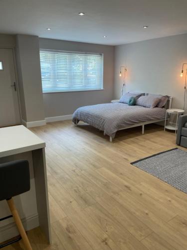 a bedroom with a bed and a window at The Woodside Snug, Eastwell, Vale of Belvoir 