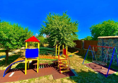 un parque infantil con un colorido columpio en un patio en Hotel Complex Bahus, en Uzhhorod