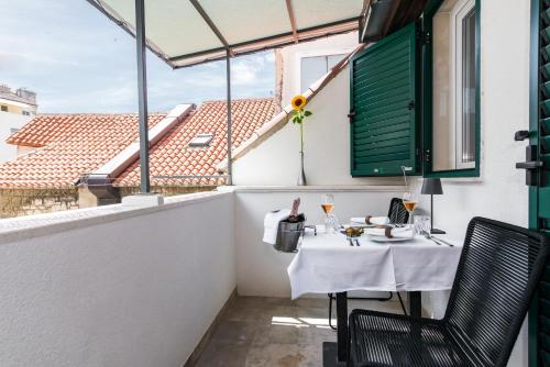 a small balcony with a table and a window at Makarun Heritage Rooms in Split